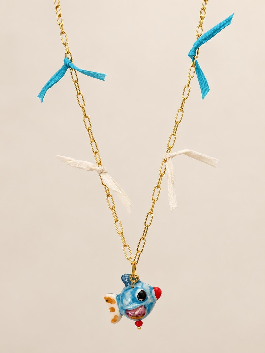 Colgante de pez azul de cerámica siciliana con cadena dorada y lacitos de seda azul turquesa y crudo
