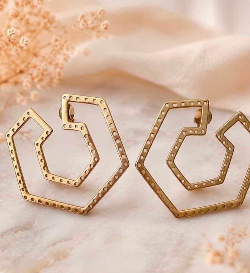 Pendientes hexagonales dorado mate sobre mármol