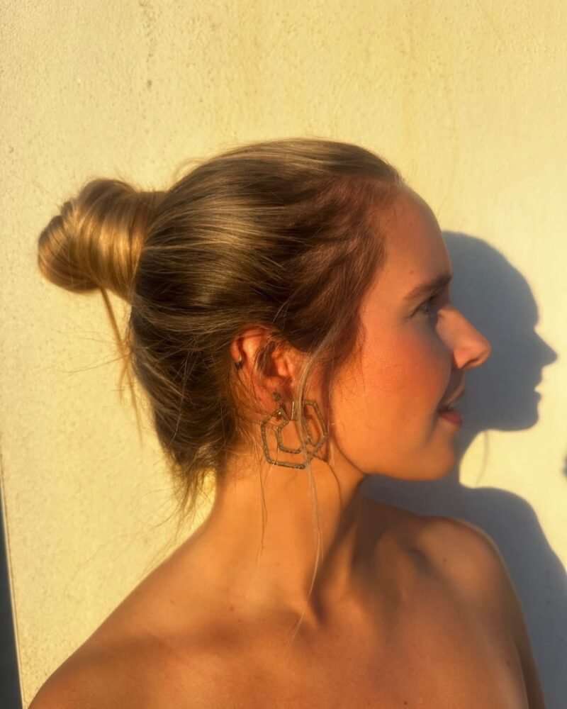 Mujer de perfil con recogido luciendo los pendientes hexagonales dorados