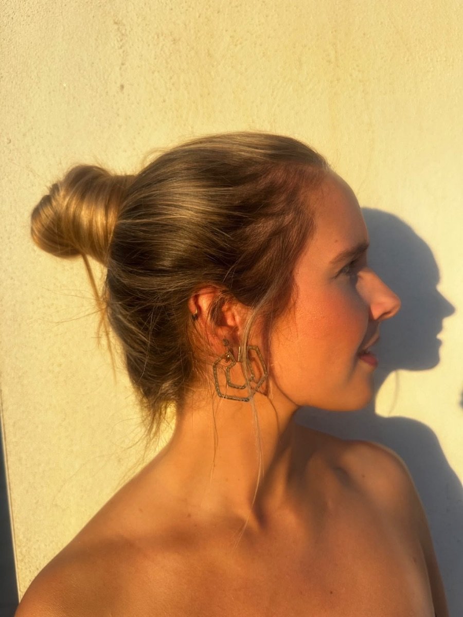 Mujer de perfil con recogido luciendo los pendientes hexagonales dorados