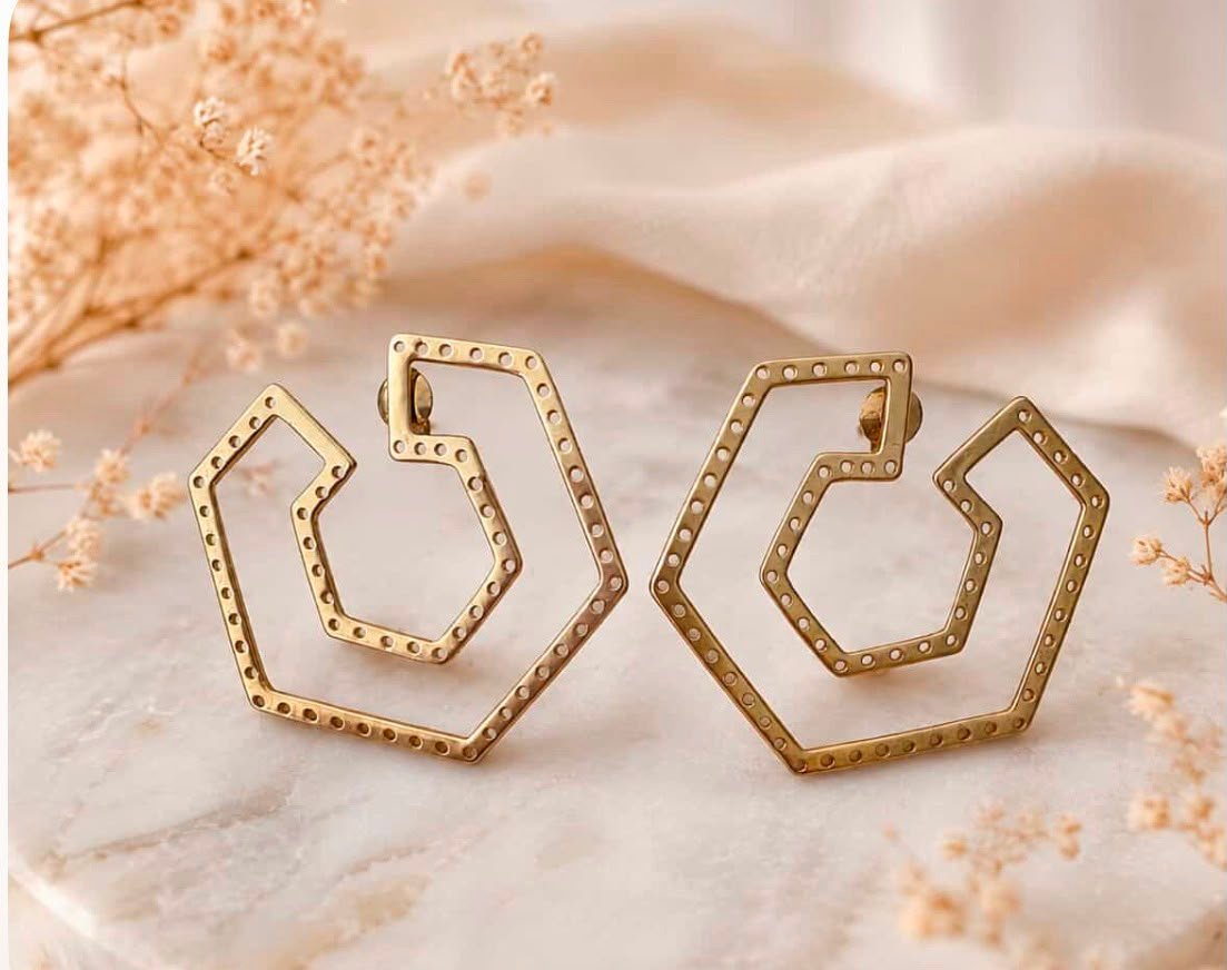 Pendientes hexagonales dorado mate sobre mármol